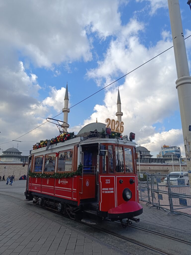 Taksim Square Istanbul with historic red tram and 2026 sign, popular tourist area in Turkey
